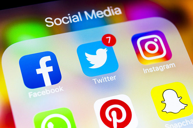Sankt-Petersburg Russia March 6, 2018: Apple iPhone X on office desk with icons of social media facebook, instagram, twitter, snapchat application on screen. Social network. Starting social media app. Photo taken at company office
